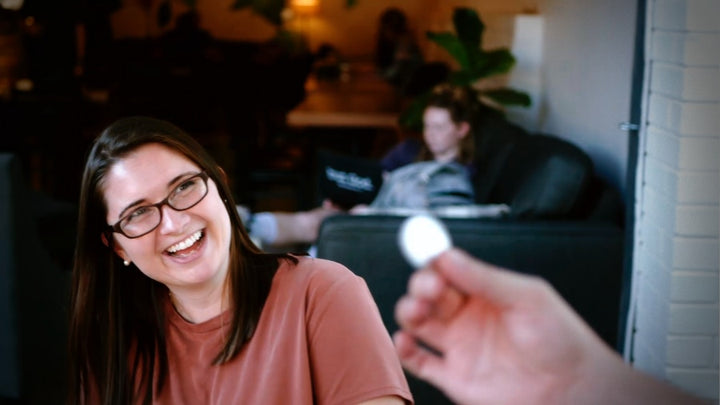 girl smiles and laughs at fun coin magic